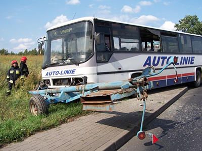 Strażacy i autobus po zderzeniu z ciągnikiem rolniczym