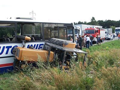 Przewrócony ciągnik rolniczy z kołem w oknie autobusu
