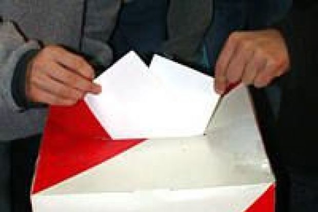 Dłonie wrzucające karty do urny wyborczej
