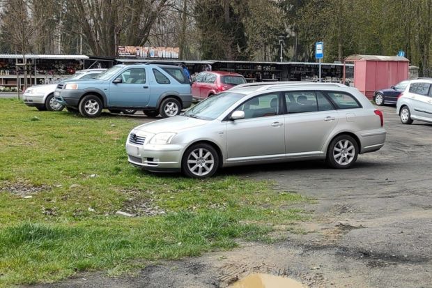 Samochody zaparkowane na trawniku koło cmentarza w Bolesławcu