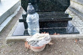 Nagrobek zadbany, a za nim schowane brudne szmaty i śmieci