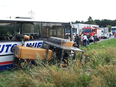 Przewrócony ciągnik rolniczy z kołem w oknie autobusu