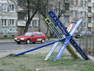 Przewrócony słup z nazwami ulic przy skrzyżowaniu