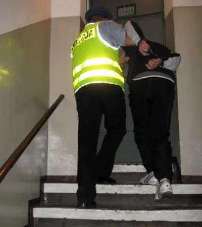 Policjant prowadzi podejrzanego o napad