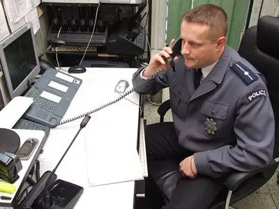 Młodszy aspirant Krzysztof Policht przy telefonie alarmowym 997