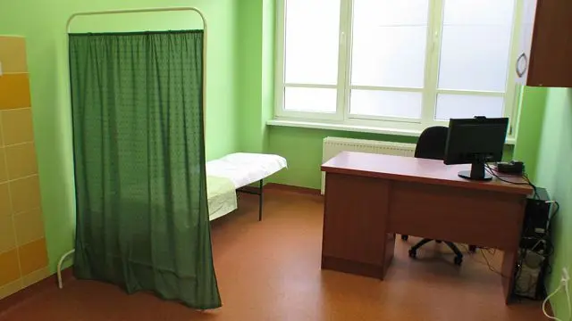 Zwykły pokój przyjęć z kozetką i biurkiem dla lekarza