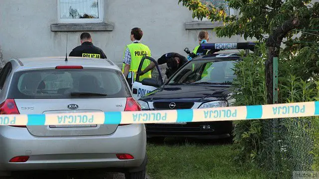 Policjanci przed budynkiem, gdzie znaleziono zwłoki kobiety