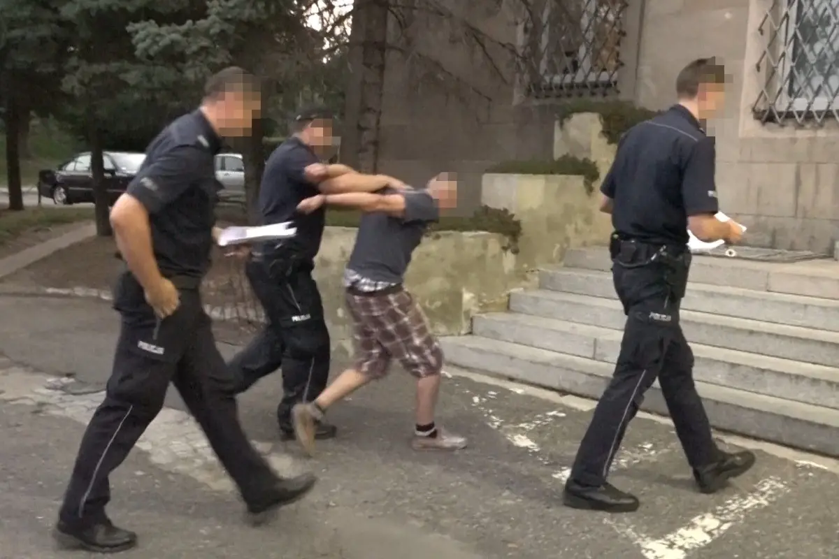Policjanci prowadzą mężczyznę, który uciekał autem