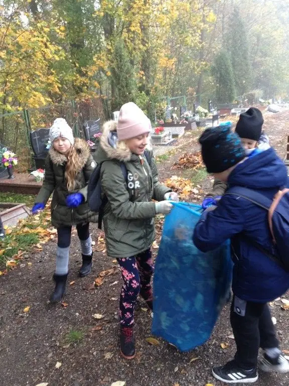 Uczniowie szkoły podstawowej nr 5 sprzątają cmentarz