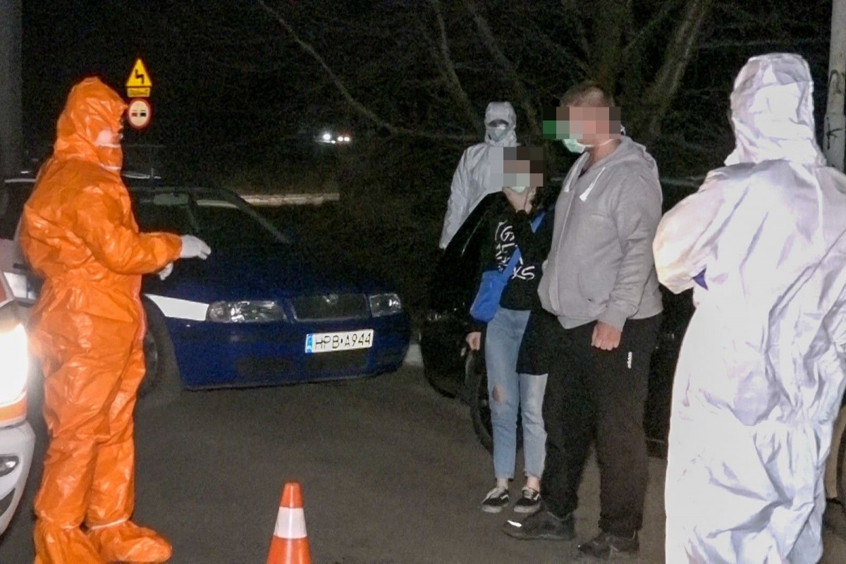 Wozy policyjne obstawiają auto z osobą podejrzaną o zarażenie koronawirusem