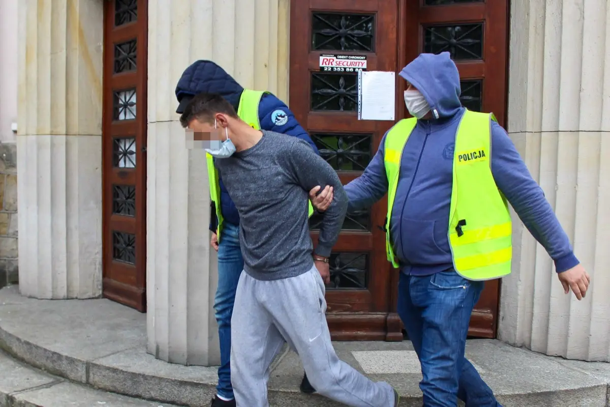 Policjanci wyprowadzają z przesłuchania w prokuraturze ojca 3,5-letniego Kacperka, który zaginął w Nowogrodźcu
