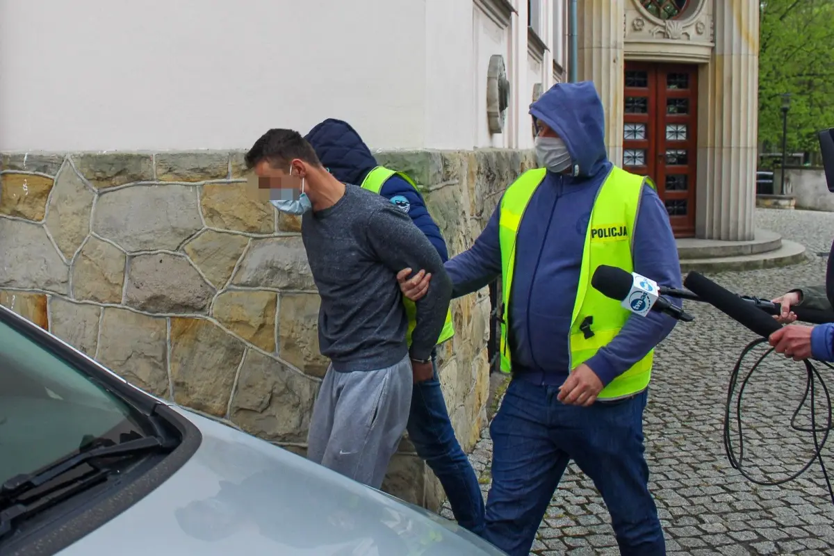 Policjanci wyprowadzają z przesłuchania w prokuraturze ojca 3,5-letniego Kacperka, który zaginął w Nowogrodźcu