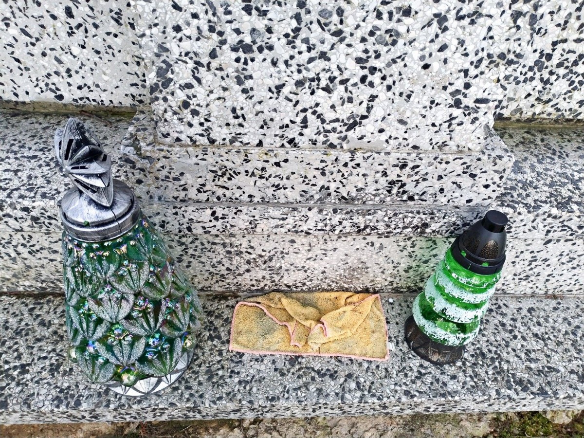 Nagrobek zadbany, a za nim schowane brudne szmaty i śmieci