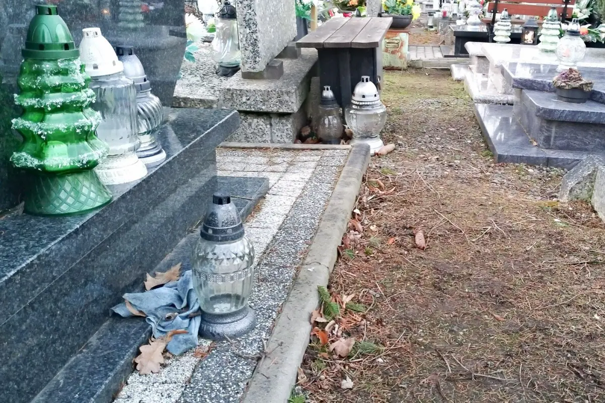 Nagrobek zadbany, a za nim schowane brudne szmaty i śmieci