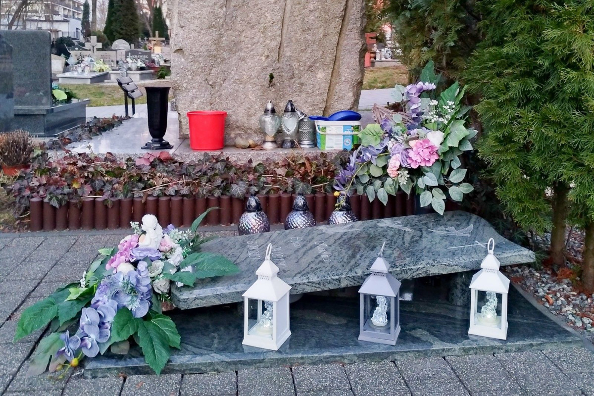 Nagrobek zadbany, a za nim schowane brudne szmaty i śmieci