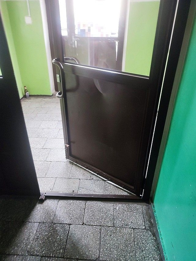 Zdemolowane drzwi w bloku przy Małachowskiego