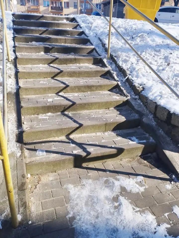 Śnieg i lód zalegają na schodach i chodnikach