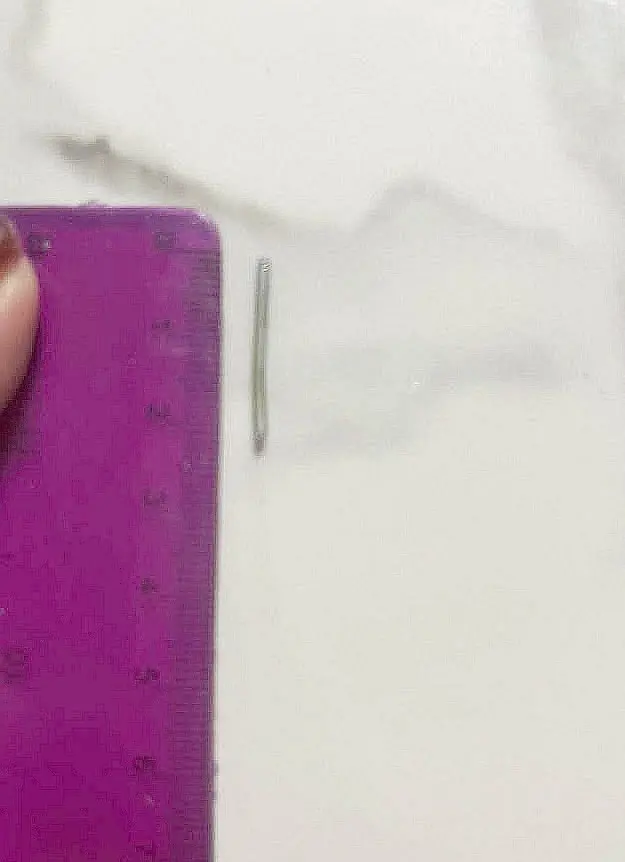 Metalowy pręt w cukierku, długość około 2 cm